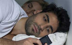 pareja en la cama con teléfono móvil